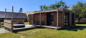 a wooden cabin with a deck in the grass at La Cabane du Gouët in Saint-Julien +7 photos