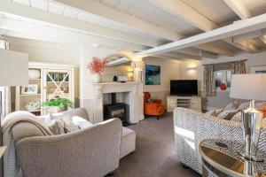 un soggiorno con divani e camino di Beautiful 3 bedroom cottage in the heart of Looe a Looe