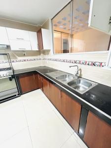 una cocina con fregadero y estufa en departamento acogedor en la Molina, en Lima