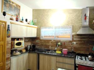 a kitchen with wooden cabinets and a sink and a stove at Casa en Playas de Oro in Villa Carlos Paz