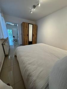 a bedroom with a large white bed in a room at Moderne Erdgeschosswohnung und eigenem Garten für bis zu 4 Personen in Ketsch