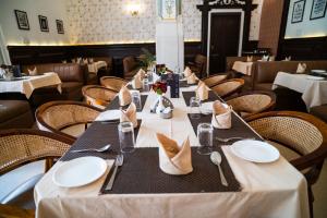 a dining room with a long table with white plates at Hotel Merwara Estate- A Luxury Heritage Resort in Ajmer