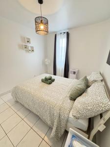 ein Schlafzimmer mit einem Bett, auf dem ein Stofftier liegt in der Unterkunft F3 confortable à 2 min du métro et ambiance cinéma in Saint-Ouen