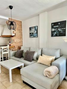 una sala de estar con un sofá y una mesa en Barrosa Living, en Chiclana de la Frontera