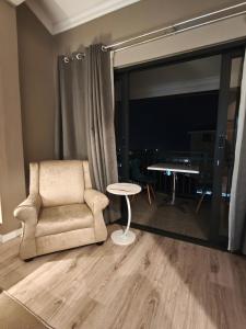a living room with a chair and a table at ARCHITECT's VIEW SUITE 1 in Durban