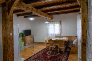 a living room with a table and chairs and a television at Casa Vlădușca in Peştera