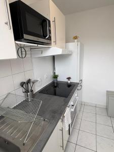 eine Küche mit einer Mikrowelle auf einer Theke in der Unterkunft F3 confortable à 2 min du métro et ambiance cinéma in Saint-Ouen + 5 Fotos