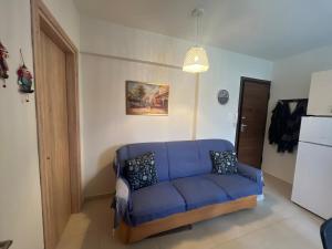 a living room with a blue couch in a room at Cozy Apartment in central Kiato in Kiaton