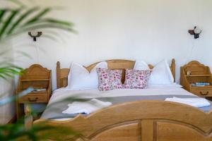 a bedroom with a wooden bed with pillows at Casa Vlădușca in Peştera
