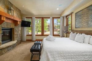 a bedroom with a large bed and a fireplace at The Porches in Steamboat Springs +291 photos