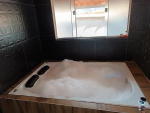 a bath tub with snow on it in a bathroom at Chalé Montanhez hidromassagem piscina in Caparaó Velho