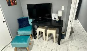 a room with a desk with a chair and a television at The Jazzy Jeffrey Gem in Baltimore