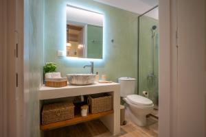 a bathroom with a sink and a toilet and a mirror at The Blue Nest in Nisís Léros +26 photos