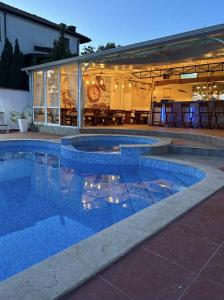 a swimming pool in front of a house at Къща за гости ГАЛАНТ in Byala
