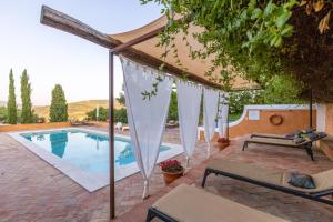 a swimming pool with an umbrella and a bench next to it at Barrieiro - Art & Nature in Marvão