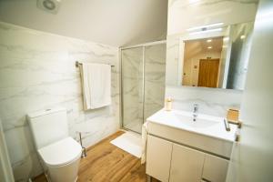 a bathroom with a toilet and a sink and a mirror at Charming Santo Antonio Roof top in Monção +55 photos
