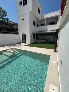 ein Haus mit einem Swimmingpool vor dem Haus in der Unterkunft Casa con PISCINA y CINE in Paterna
