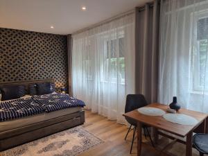 a bedroom with a bed and a table and a dining room at Zentroom studio apartment in Flensburg