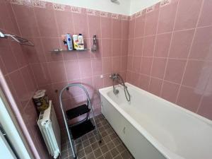 a pink bathroom with a bath tub and a sink at Уютная квартира в 10 минутах от моря in Aseri