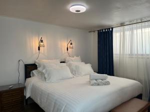 a bedroom with a large bed with white sheets and pillows at Paris Expo Porte de Versailles Malakoff Appart 2 pièce in Malakoff