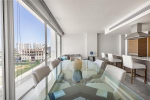 カンクンにあるLuxury 3BR Condo* rooftop pool, near the beachのガラスのテーブルと椅子のあるリビングルーム