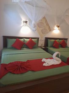 a bedroom with two beds with a swan on it at The Cozy Cottage Habarana in Habarana