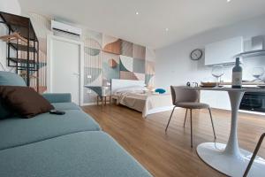 a living room with a couch and a table and a bed at SolVerdi in Oristano