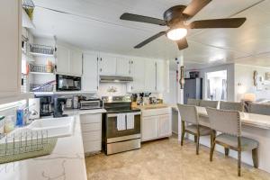 a kitchen with white cabinets and a table and chairs at 2 Mi to Public Beach Pet-Friendly Freeport Home! in Freeport