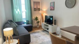 a living room with a couch and a tv at MEAUX Centre Vue Cathédrale RDC Cosy in Meaux