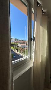 a window with a view of a city at La Cachette du Sud in Vallauris