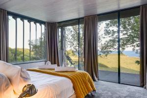 Un dormitorio con una cama y grandes ventanales. en The Bunker - Ventnor, en Ventnor