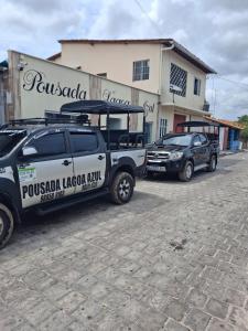 Un camión blanco y negro estacionado frente a un edificio. en Pousada lagoa azul, en Santo Amaro