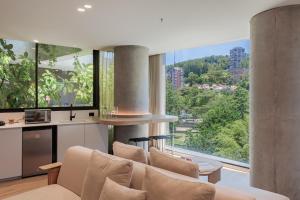 a living room with a couch and large windows at Seissta Medellín in Medellín