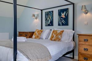a bedroom with a white bed with a black frame at Ash View 2 in Corsley