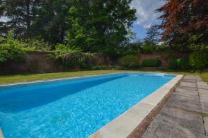 une piscine avec de l'eau bleue dans une cour dans l'établissement Landfords Cottage, à Landford