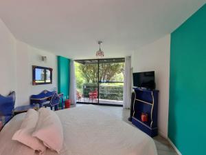 a bedroom with a bed and a flat screen tv at HOTEL EL PAN NUESTRO in Tepoztlán