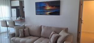 a living room with a couch and a painting on the wall at Ilha Pura BARRA apart in Rio de Janeiro