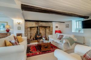 ein Wohnzimmer mit weißen Möbeln und einem Steinkamin in der Unterkunft Rose Cottage - Powerstock in Powerstock