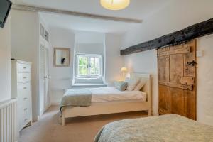 ein Schlafzimmer mit zwei Betten und einem Fenster in der Unterkunft Rose Cottage - Powerstock in Powerstock