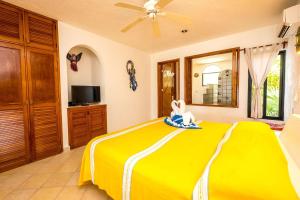 a yellow bed in a room with a ceiling fan at Luna Azul Unit 1 in Akumal
