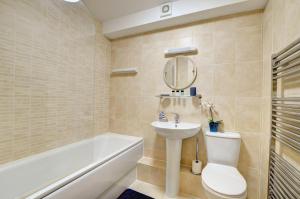 a bathroom with a sink and a toilet and a bath tub at Flat 3 Penlu in Swanage +5 photos
