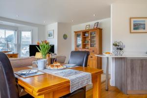 Un comedor con una mesa de madera y una cocina. en Hazelhurst, en Freshwater