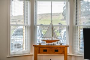un bote modelo en una mesa frente a las ventanas en Hazelhurst, en Freshwater