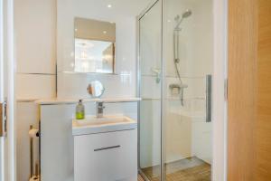 Un baño blanco con lavabo y ducha en Hazelhurst, en Freshwater 14 fotos más