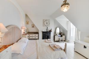 スワネージにあるUpper Nestleton Maisonetteの白いベッドルーム(大型ベッド1台、時計付)