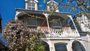 スワネージにあるUpper Nestleton Maisonetteの白いバルコニーと木のある家