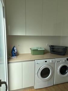 a kitchen with a washing machine and a washer at Aroeira Beach Home in Almada