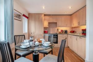 cocina con mesa de cristal con sillas y mesa en Maritime House Apartment, en West Bay