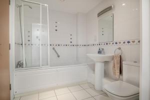 Un baño con lavabo, inodoro y ducha. en Maritime House Apartment, en West Bay 10 fotos más
