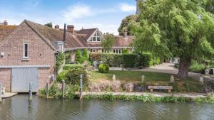 a house by the water with a canal at Riverside Cottage - Wareham in Wareham